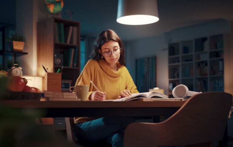 motivated student studying in the night at home user lights.